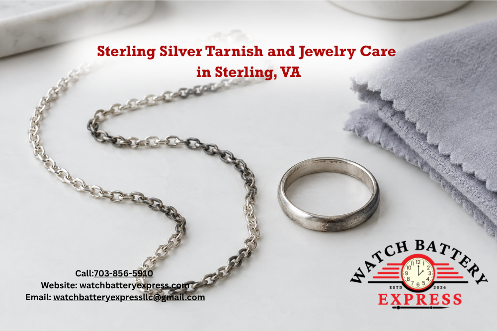 Silver-colored chain necklace and ring with dark tarnished areas beside a folded polishing cloth on a white surface.